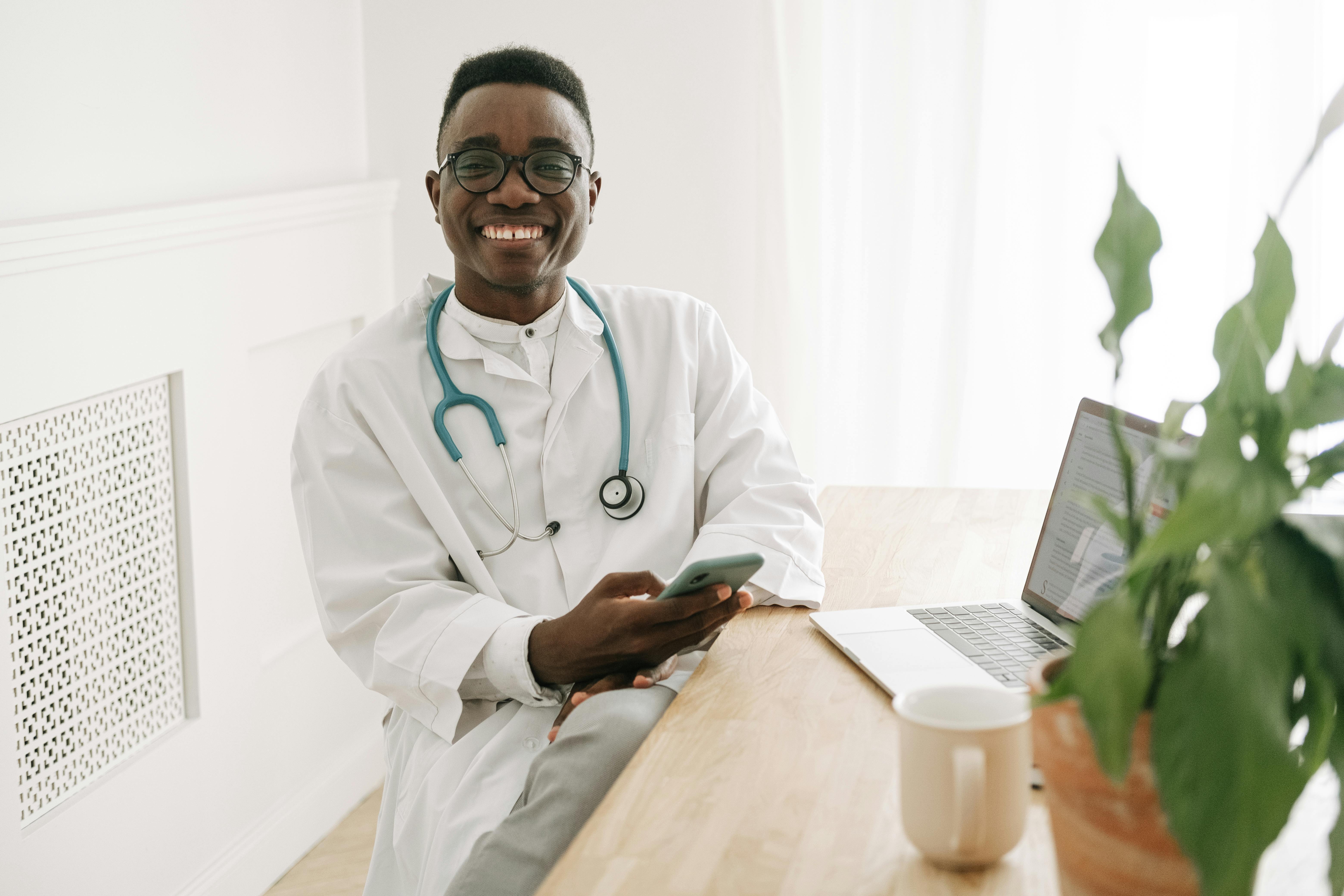 Smiling male doctor with stethoscope ready to help