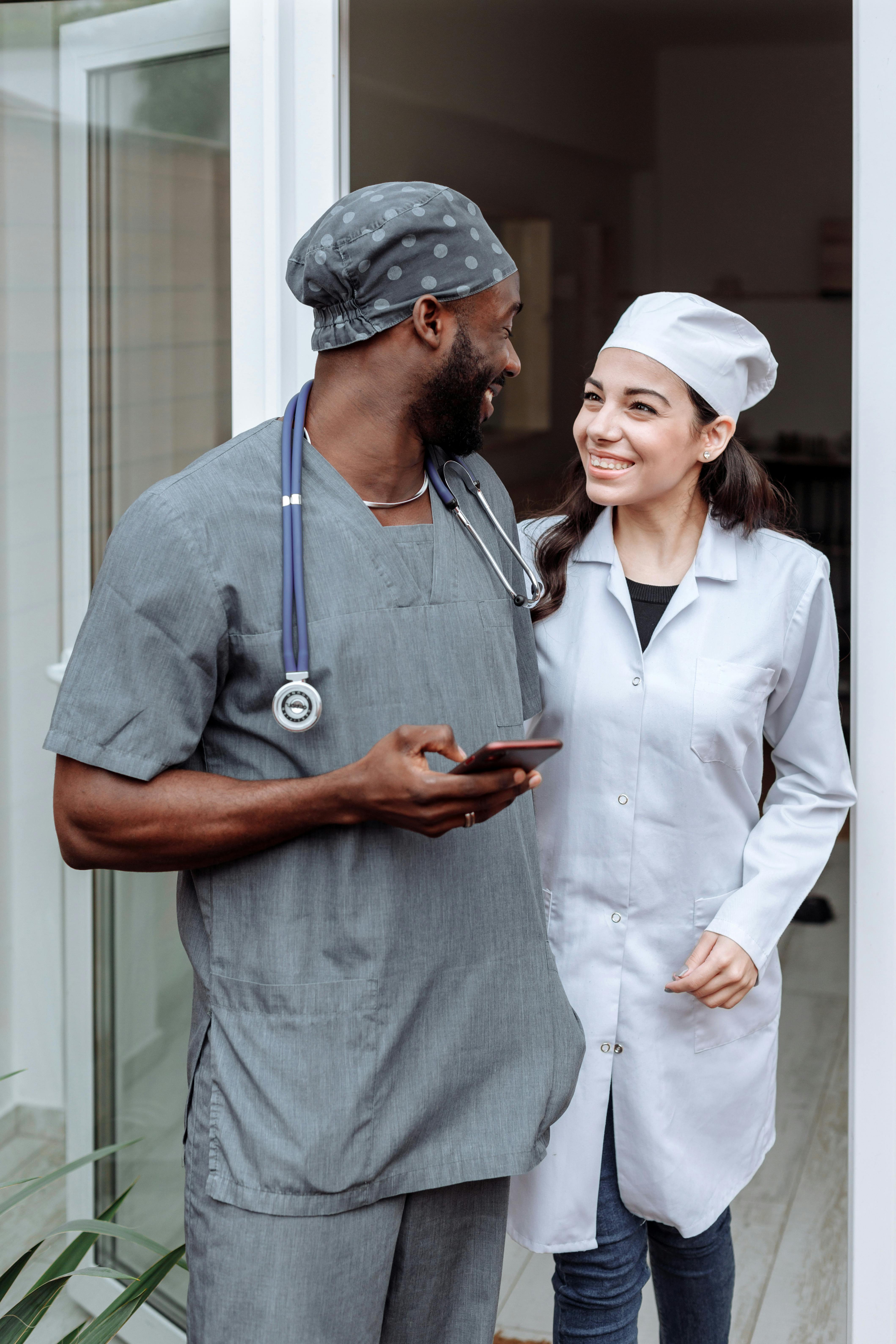 Two diverse doctors smiling together at a clinic